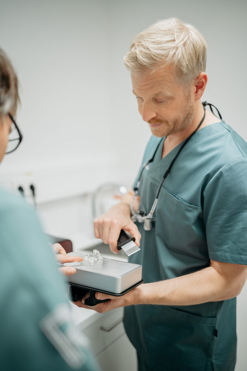Dr. Dr. Johan Rieth prüft gemeinsam mit einer Assistentin den 3D-Druck eines Gebisses.